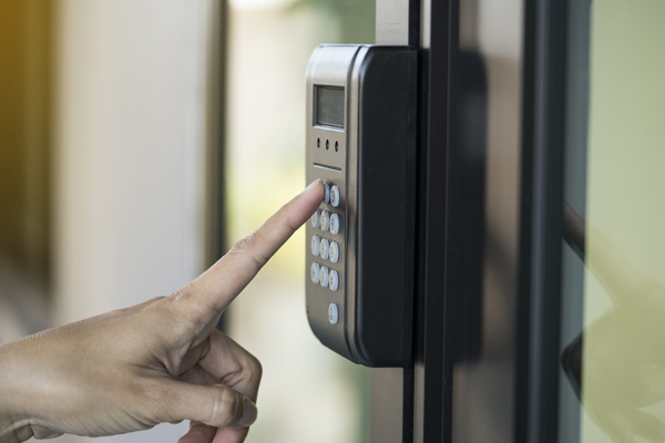 Hand pressing buttons on a digital keyless door lock